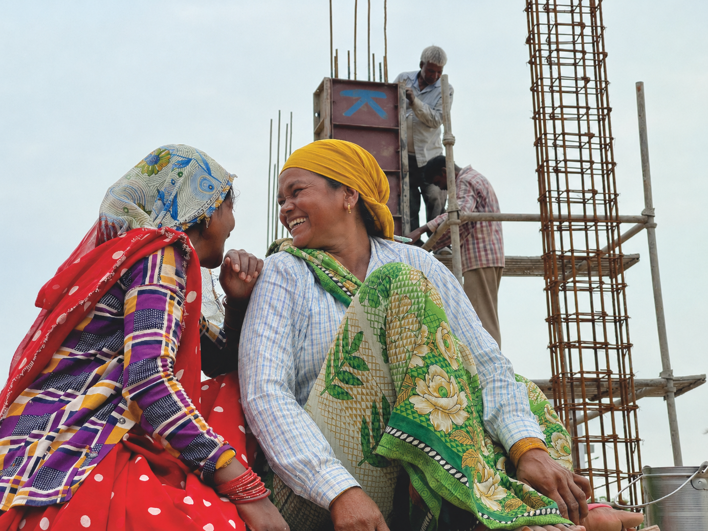Two women workers in conversation at a worksite